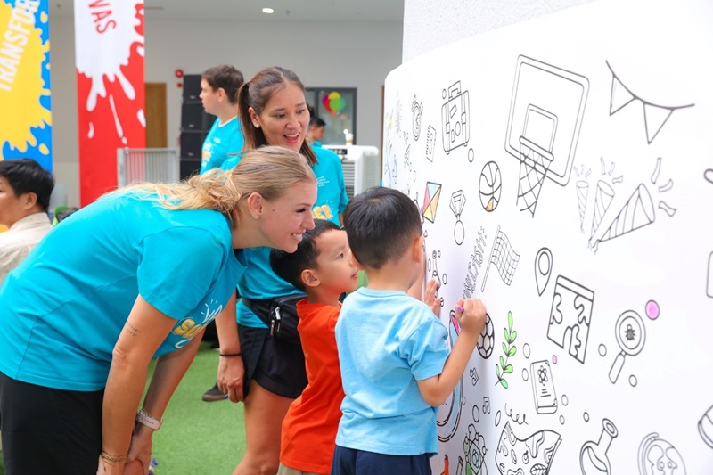 A group of people looking at a white board with drawingsDescription automatically generated